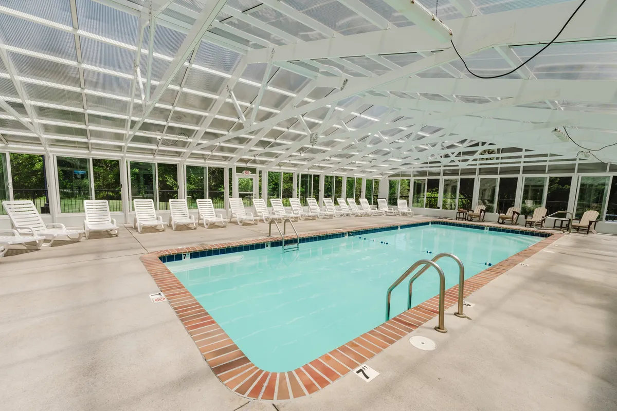 An inviting indoor swimming pool area complete with lounge chairs and large windows letting in natural light. This amenity offers a fun and relaxing on-site entertainment option for small groups, complementing the local adventure and nightlife.